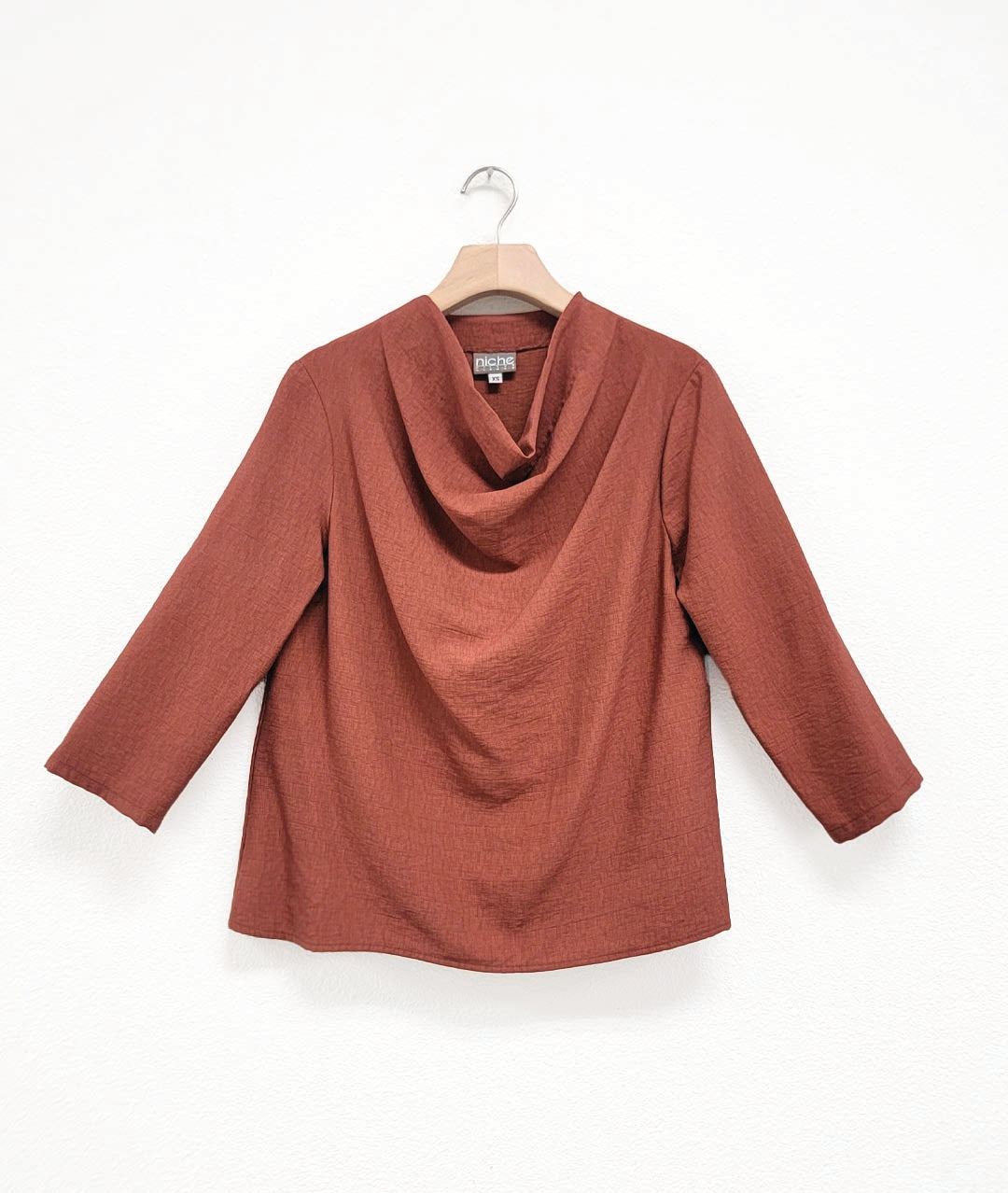rust color pullover top with 3/4 sleeves and a high cowl neckline