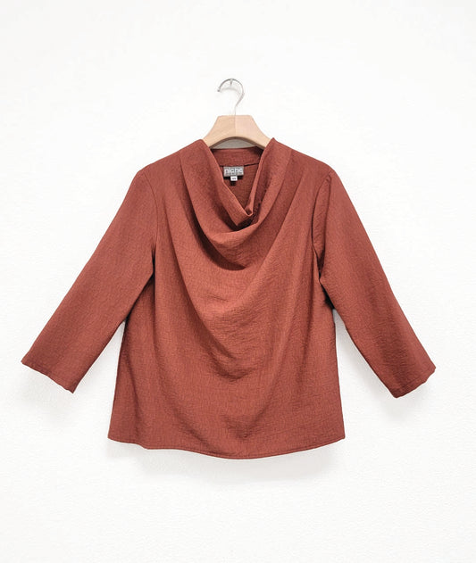 rust color pullover top with 3/4 sleeves and a high cowl neckline