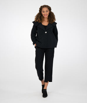 model is wearing all black with black booties against a white background
