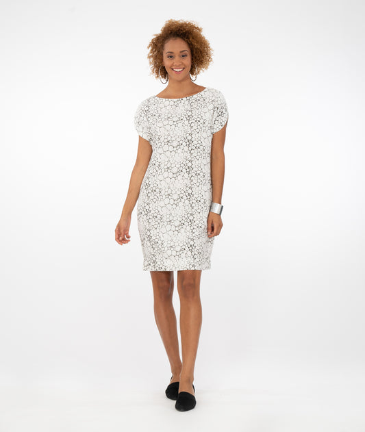 model in a white shift dress with a bubble print. dress is knee length with a round neckline and a split cap sleeve