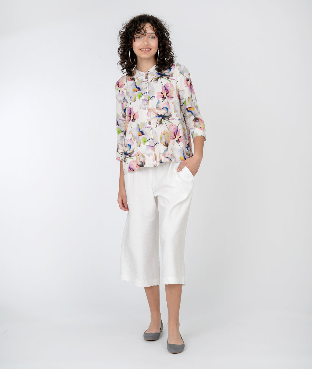 model in a cropped wide leg white pant with a floral print button down blouse with a 3/4 sleeve