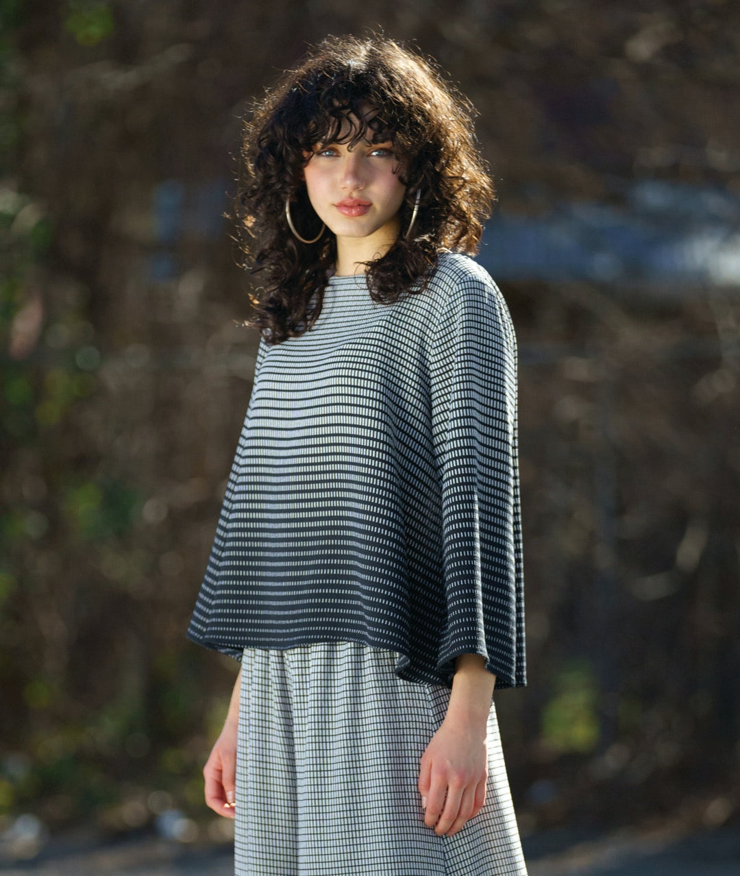 model in a boxy pullover top in a black to white grid print gradient. worn with a matching extra wide leg pant in a matching fabric