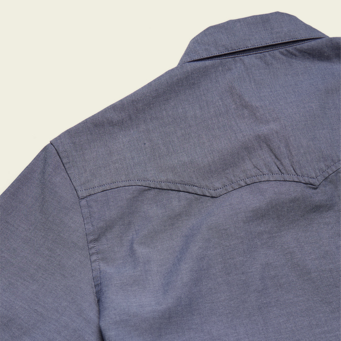 Close-up of a blue shirt on a beige background