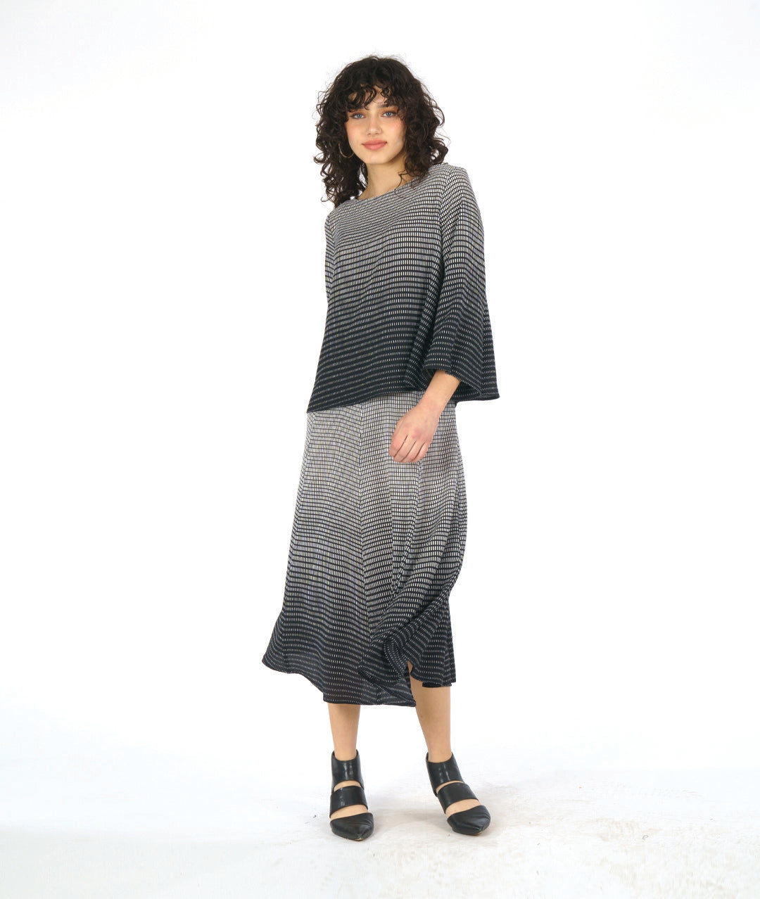 model in a black and white ombre grid print paneled skirt with a matching boxy top