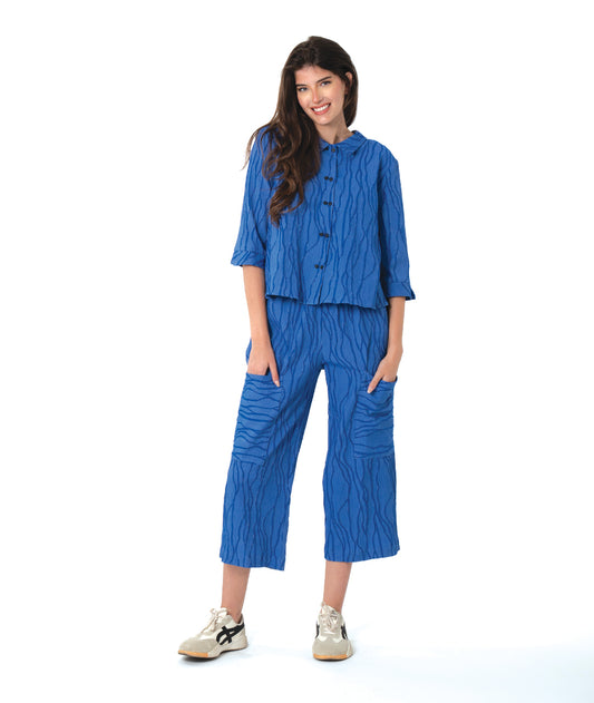 model in a boxy blue button down blouse with a matching straight leg cargo pant.