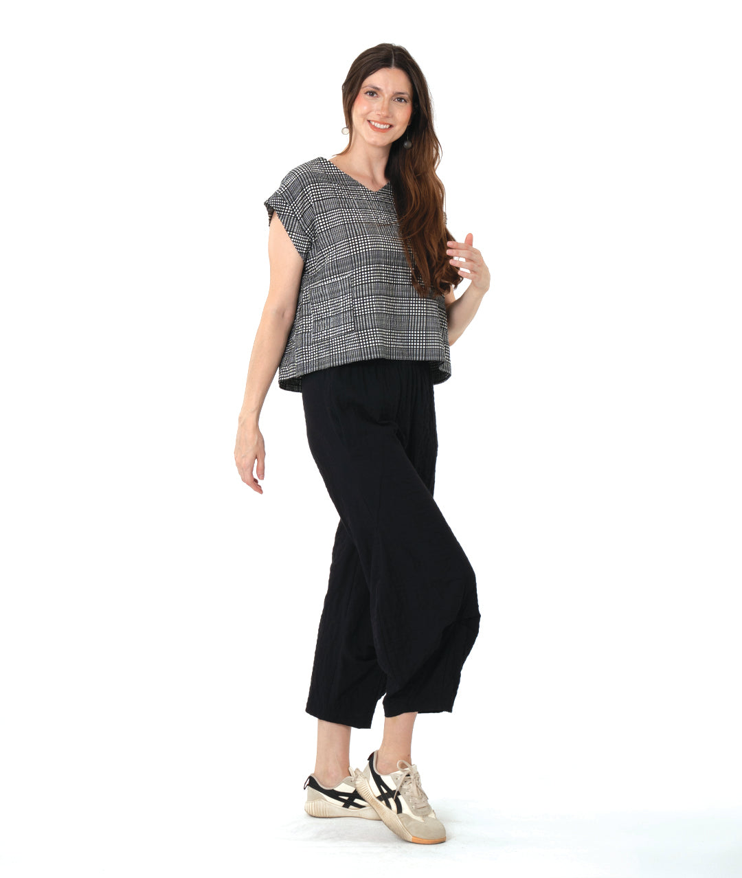 model in a checker print pullover boxy top with a black pant with an elastic waist and tucks at the center front legs