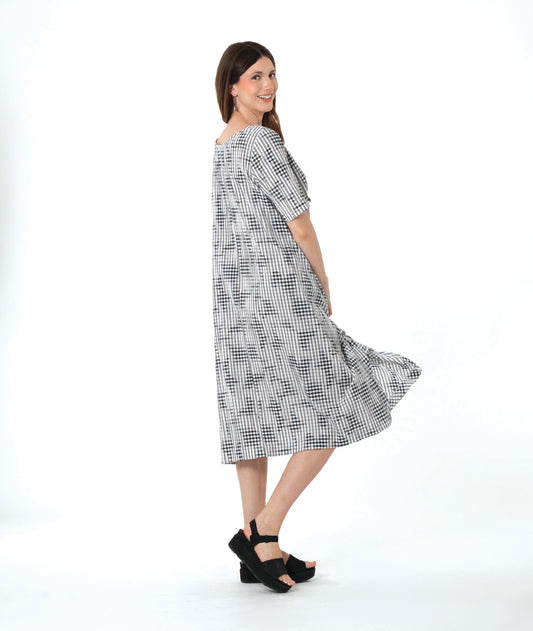 model in a grey plaid dress with asymmetrical tucks and panels