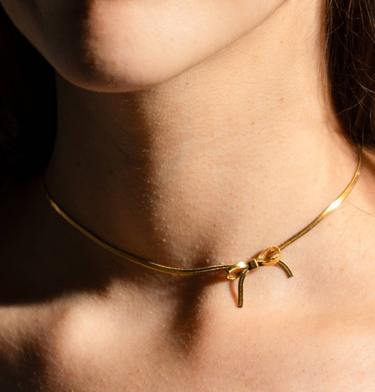 thin gold choker with a bow charm