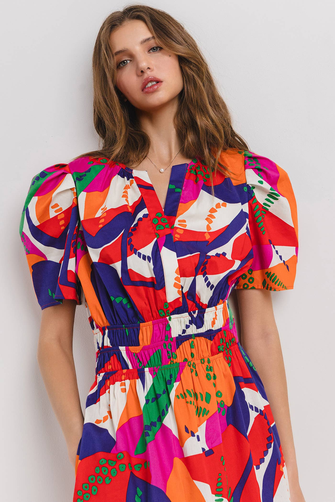 close-up of model wearing a tropical printed dress with puffy sleeves