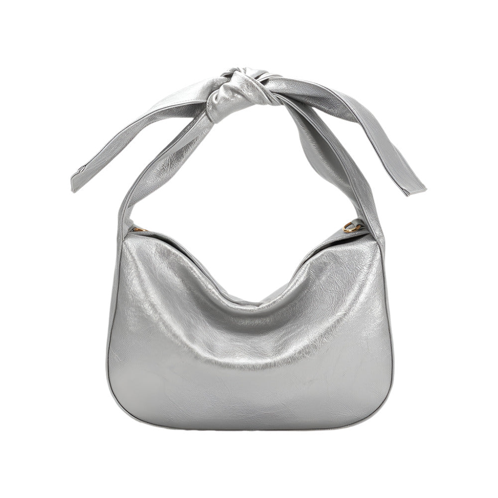 Silver handbag with a bow as the strap on a white background