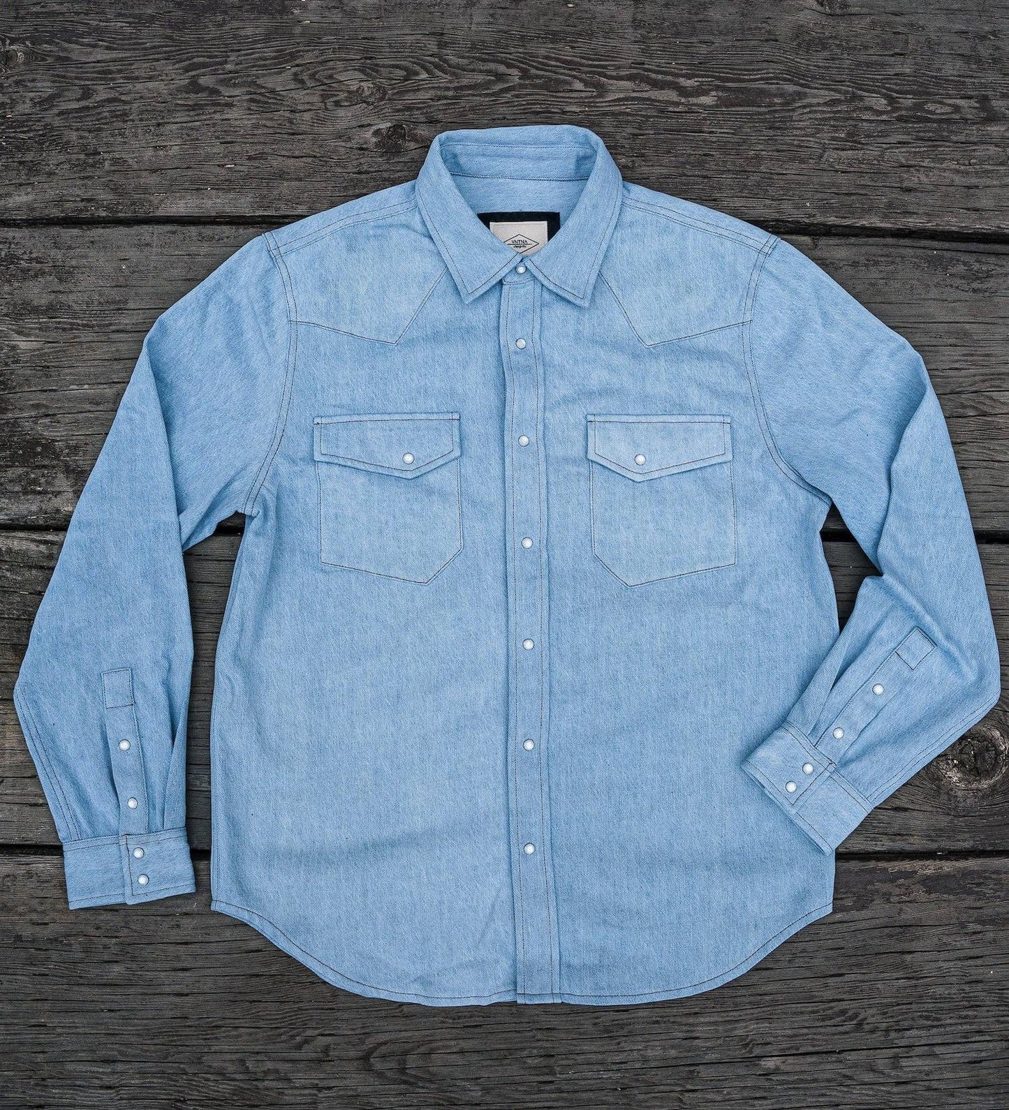 Light blue denim shirt on a wooden surface