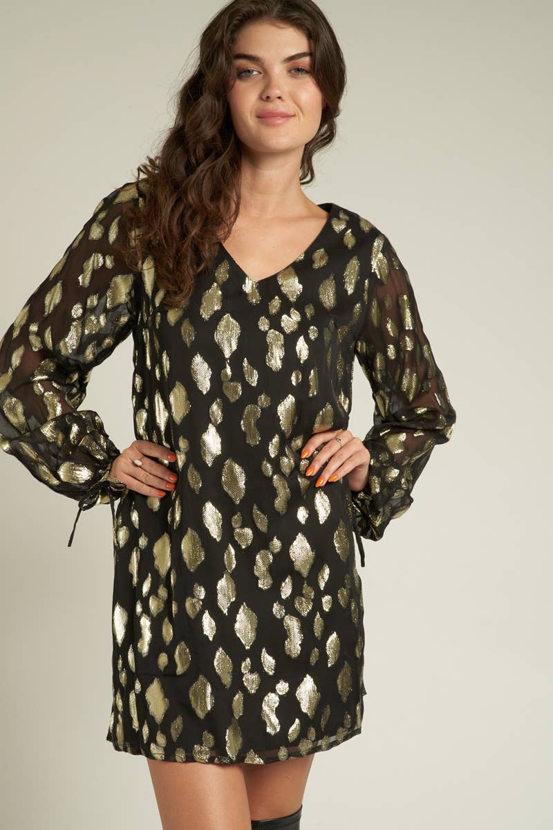model is wearing a black long sleeved dress with gold sparkly spots