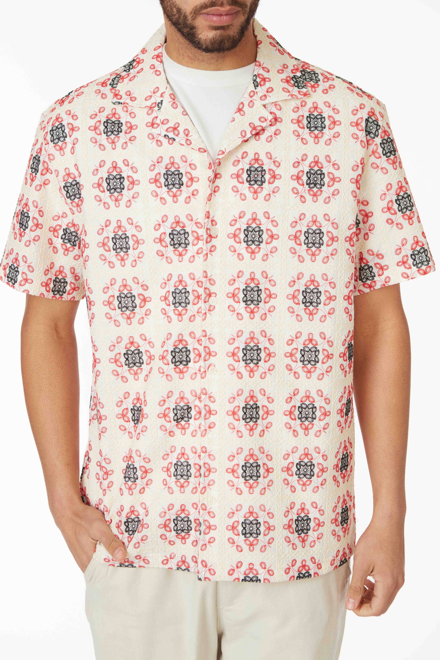 model in a short sleeve button down top with a red and blue floral print