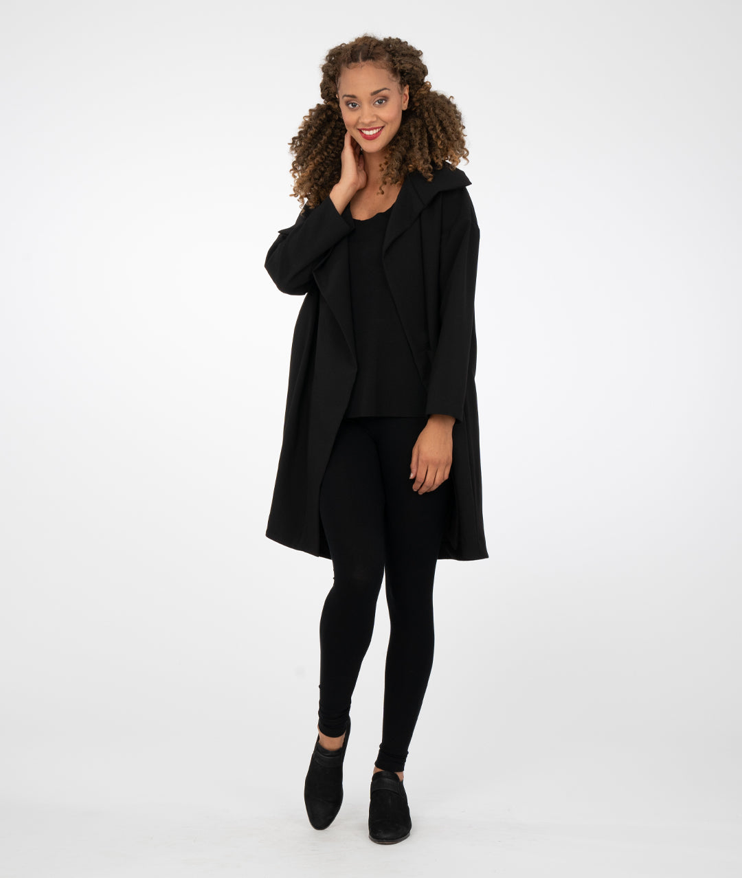 model in black leggings with a black asymmetrical jacket with a large collar