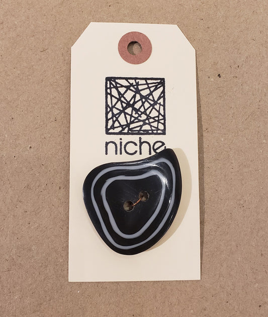 black button with white trim on a Niche card