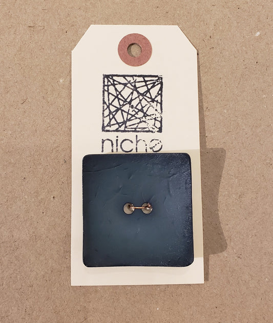 matte black square button on a Niche card