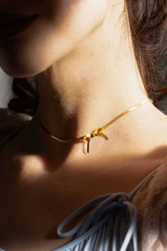 thin gold choker with a bow charm