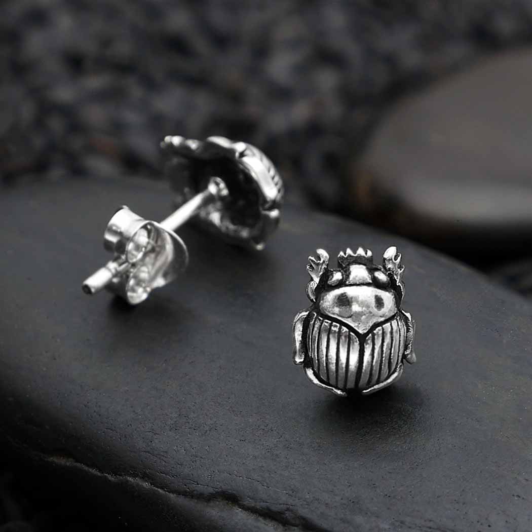 A pair of sterling silver post earrings designed with a scarab motif.