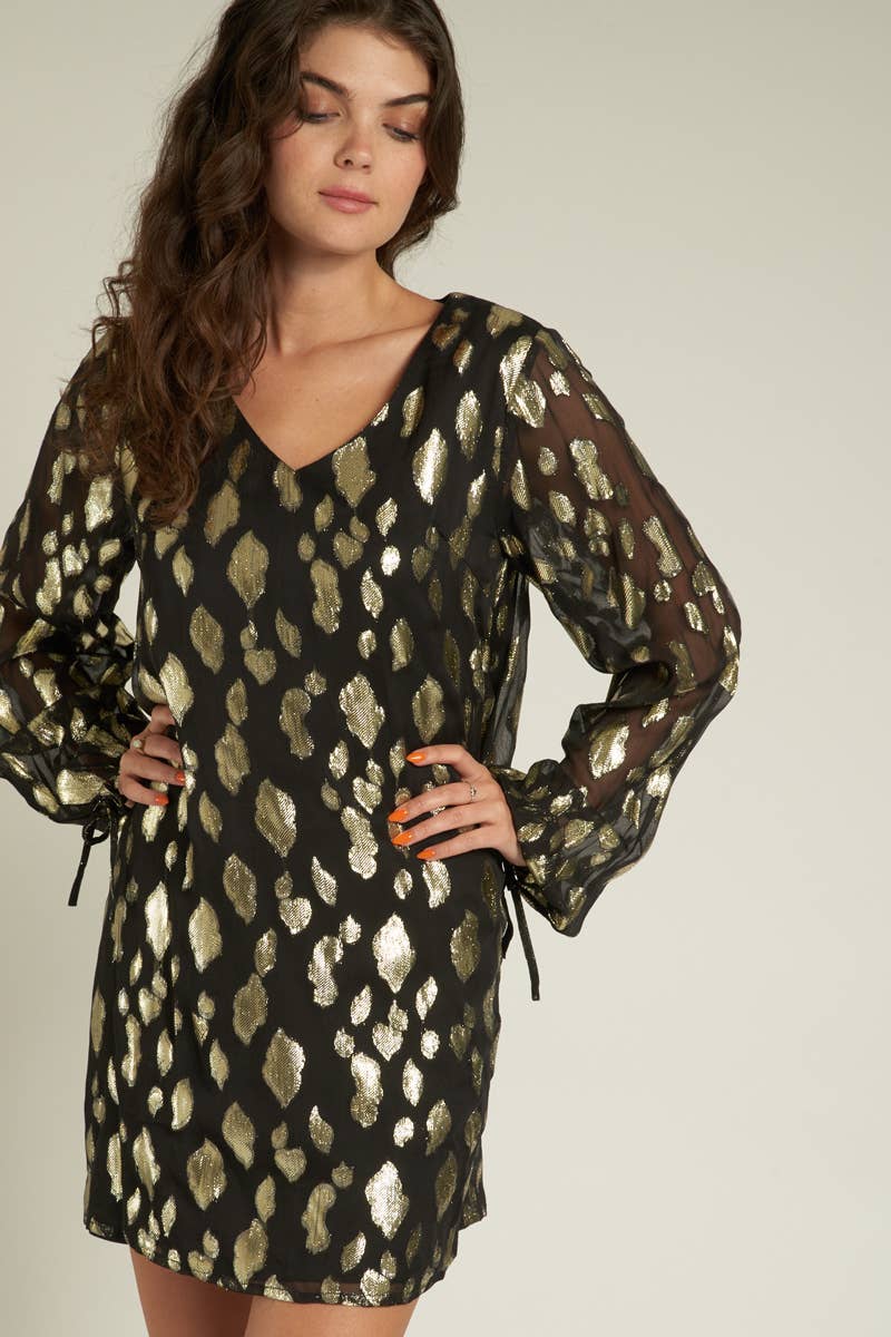 model is wearing a black long sleeved dress with gold sparkly spots