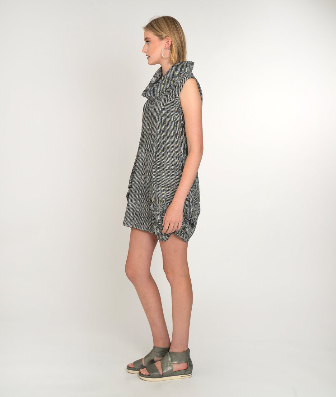 model in a black and white striped tunic with a cowl neck, princess seams, pockets and a pleating detail at the hips