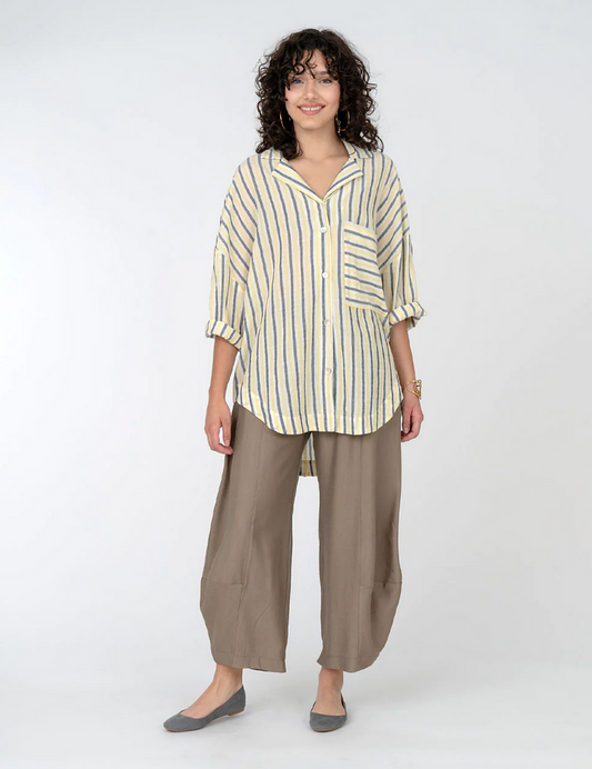 brunette model wearing yellow and black stripe top and khkai pants with bubble hem. On a white background.