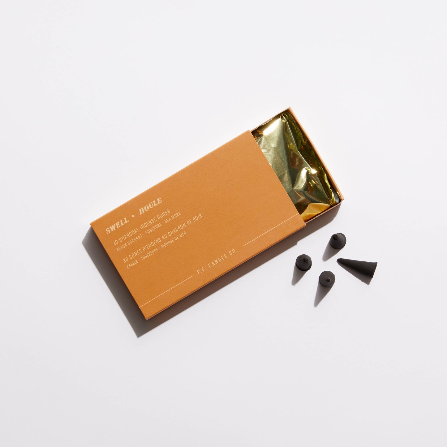 box containing incense cones with the cones next to it