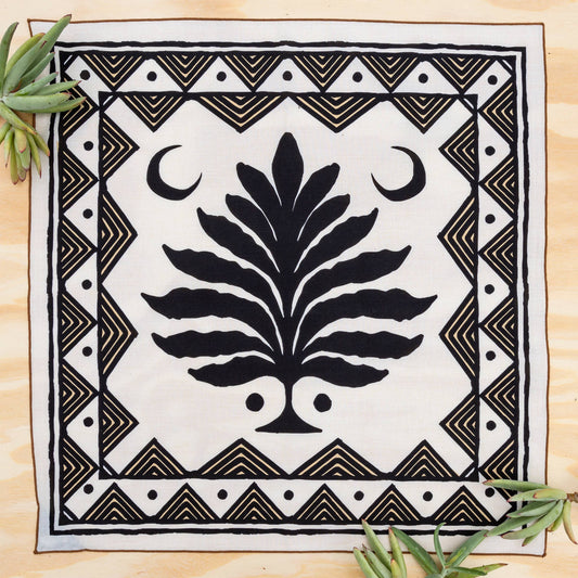 bandana shows an aztec print surrounding a tree with two crescent moons on either side
