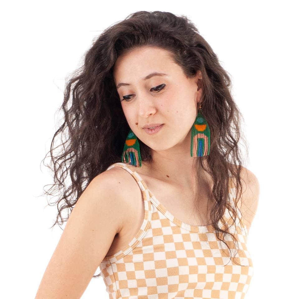 Glass seed beads and gold plated french ear wire earrings in teal, green, aqua and peach. on a brunette model wearing a tan and white checkered tank top and white background