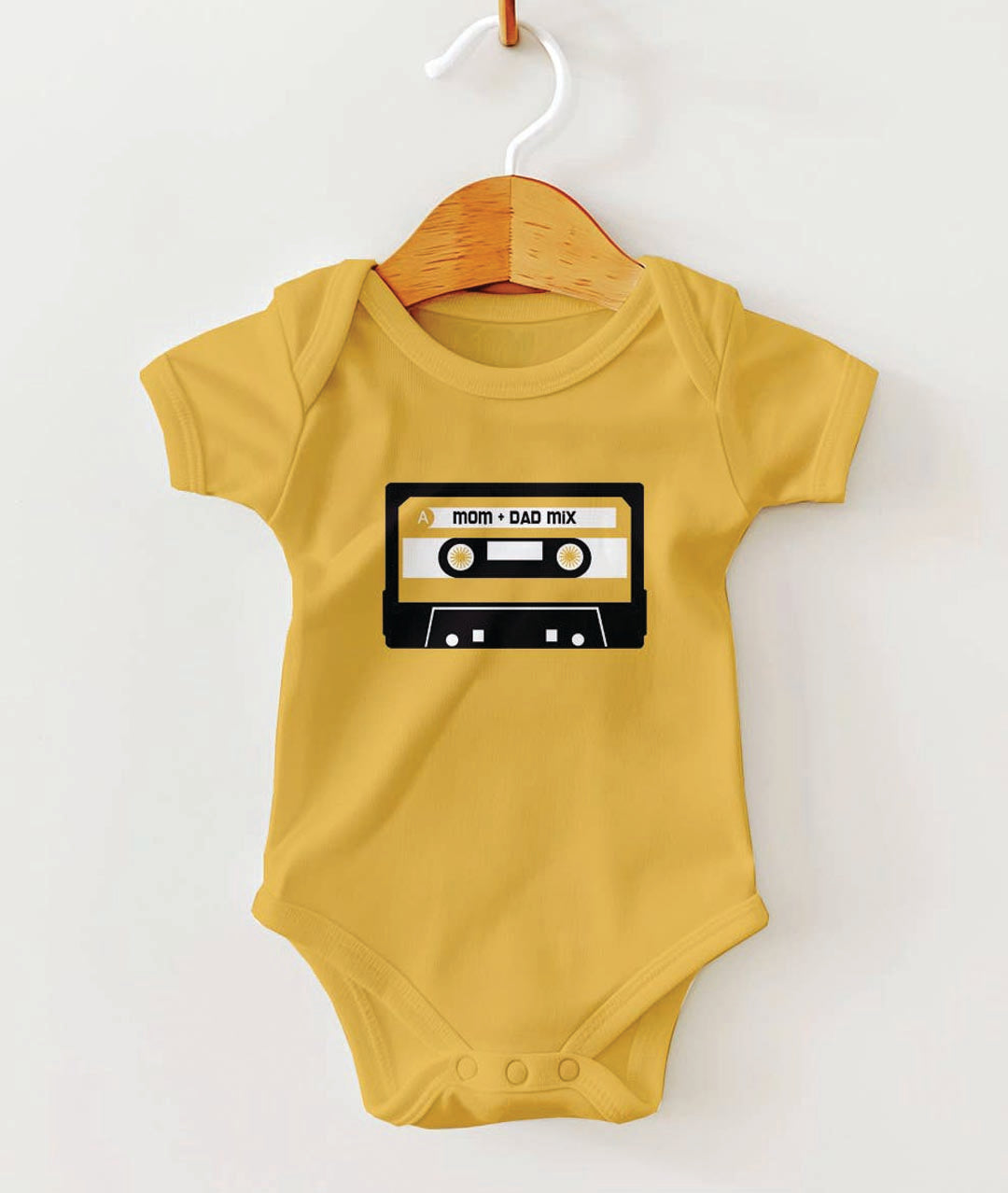 Yellow baby onesie with a cassette tape design on a white background