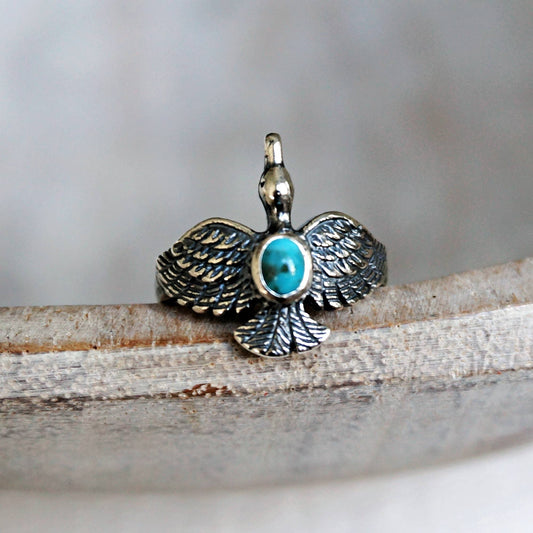 Silver pendant with turquoise stone on a wooden surface