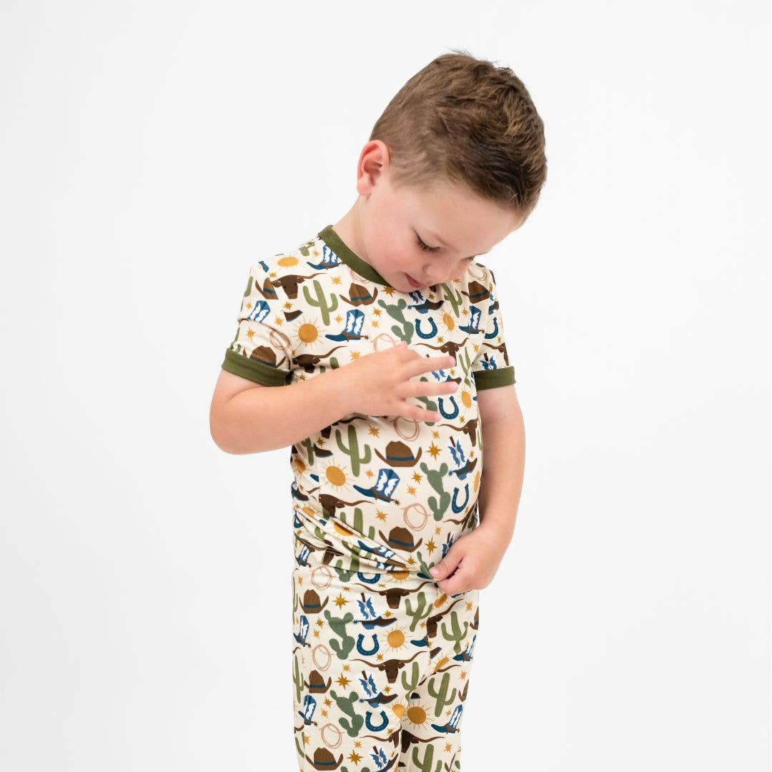 Child wearing a pajama set with a cactus pattern on a white background