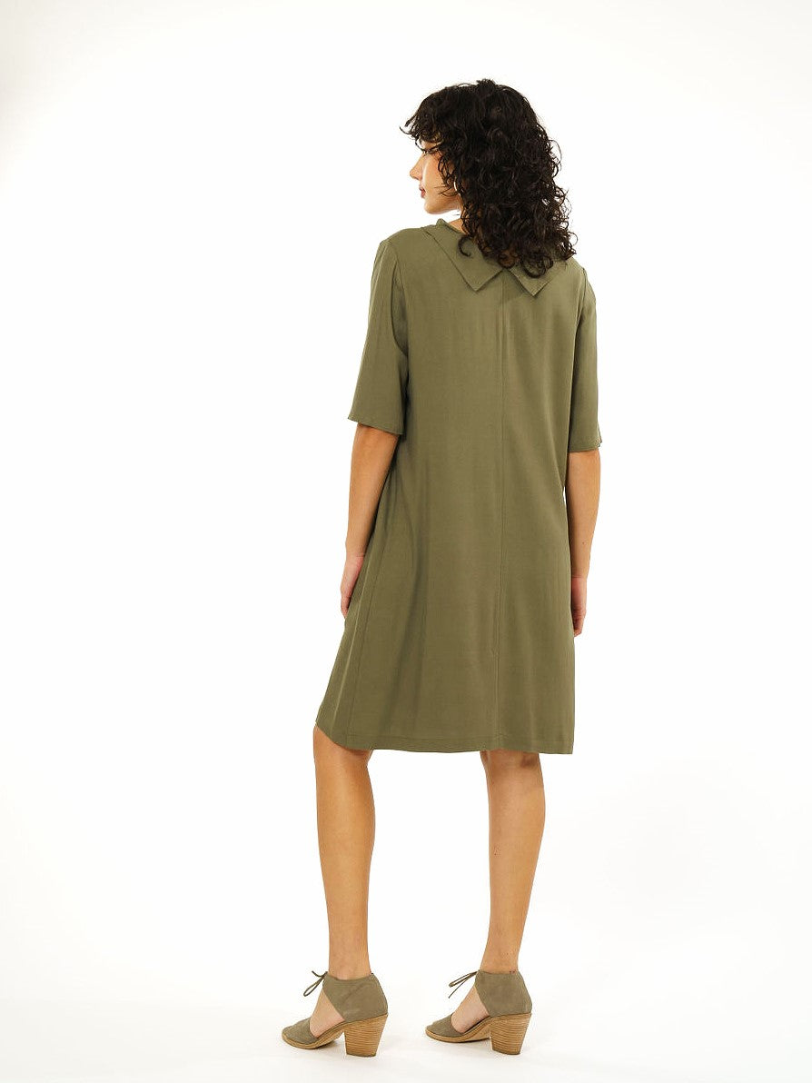 back view of brunette model in knee length olive green dress  with elbow length sleeves and a split collar in the back. on white background