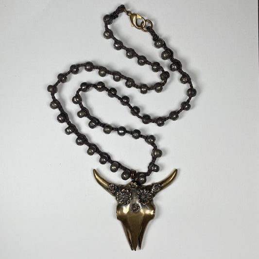 Bronze Cattle skull with flower crown pendant on a necklace of dark dyed bronze beads.