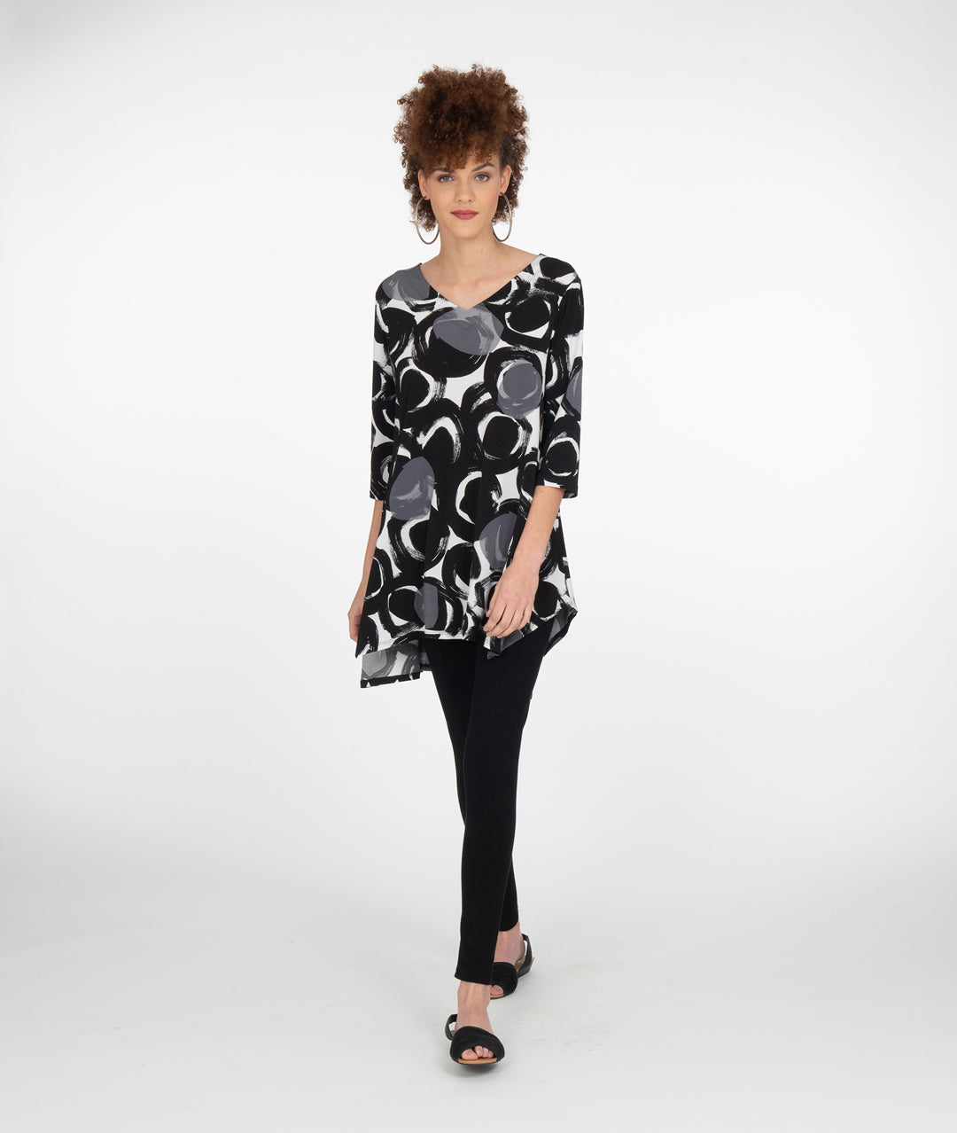 model in black leggings with a black, white and grey circle print tunic with a high-low hem and a vneck