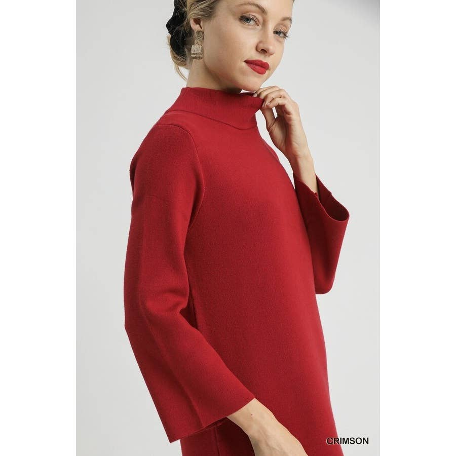 Woman wearing a red midi mock neck knit dress on a white background