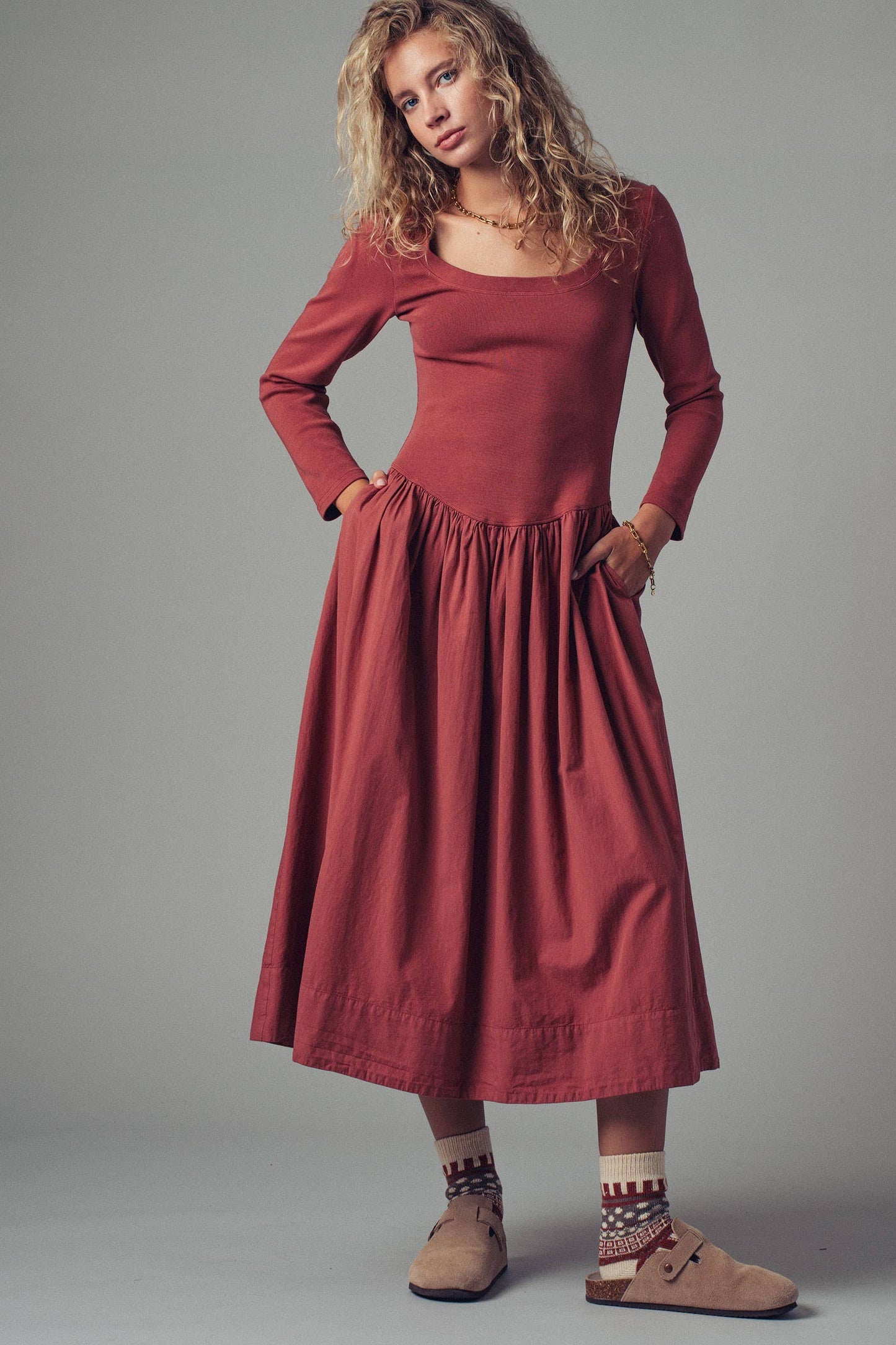 Woman wearing a red dress against a gray background