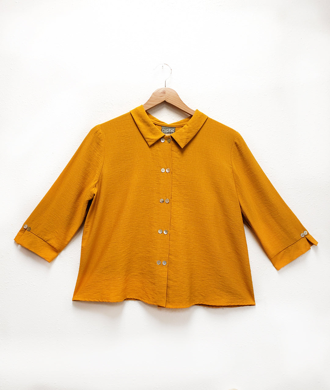 saffron yellow button down blouse with twin button up the front placket. Each sleeve cuff has a split and twin buttons.