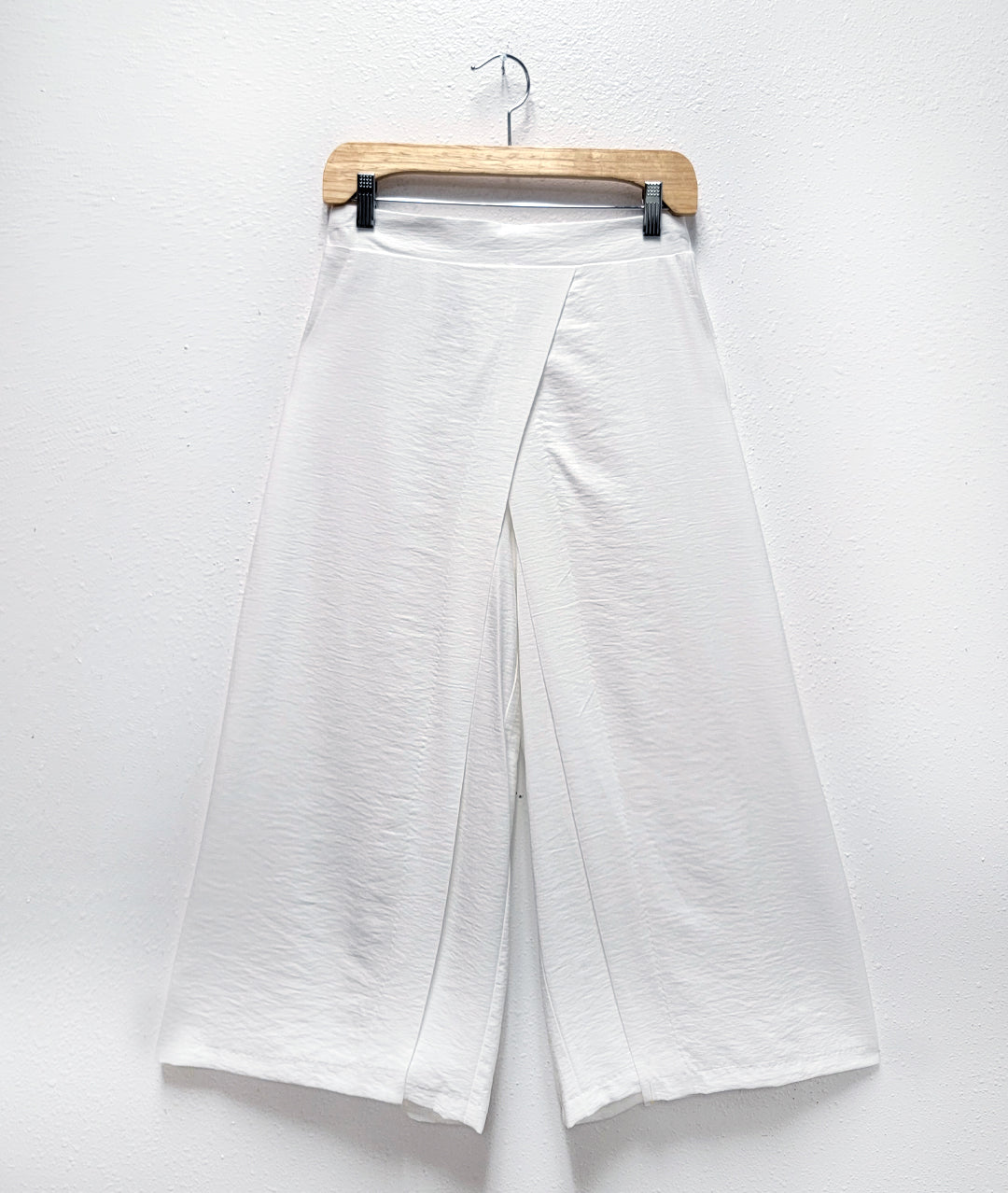 wide leg white pant with an overlapping panel on both legs, crossing in the front