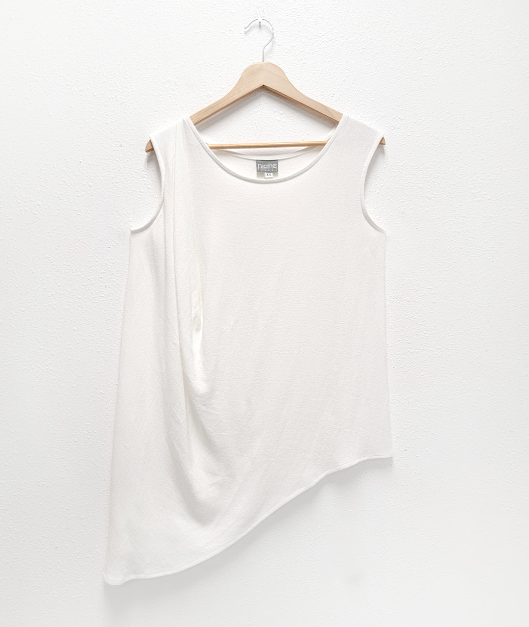 White sleeveless top with beautiful gather at one shoulder and asymmetrical hemline. 