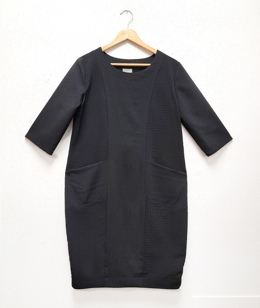black textured shift dress with 3/4 sleeves and princess seams with hip pockets