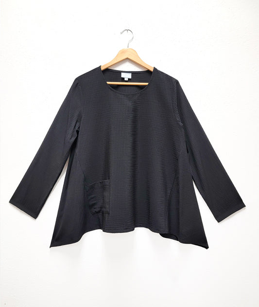 black pull over top with a single squared hip pocket, long sleeves and a hankerchief hemline