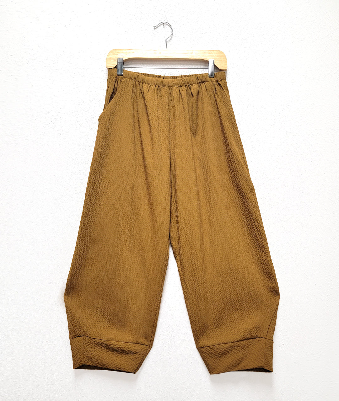 dijon yellow textured pant with pockets, an elastic waistband, and a tapered cuff at the bottom hem