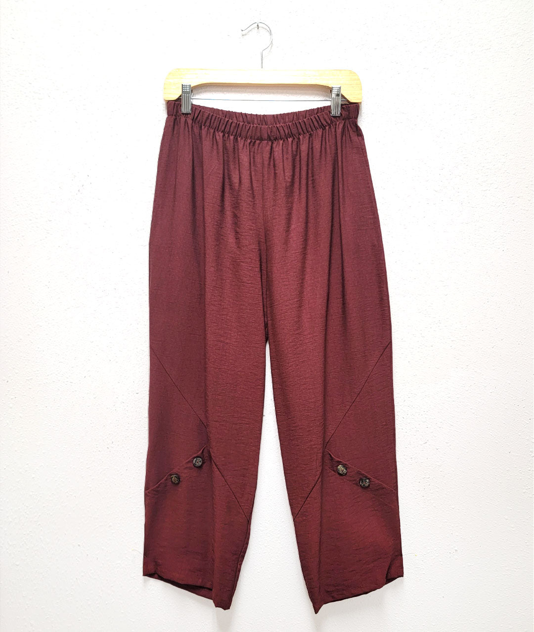cinnamon color elastic waist pant with a button detail at the legs