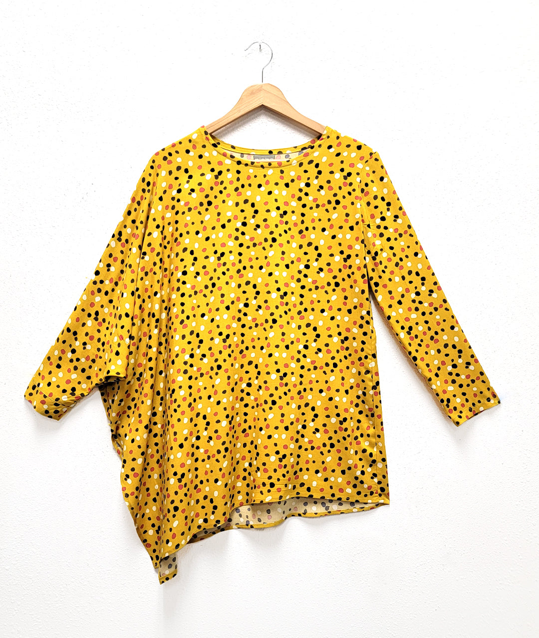mustard yellow dot print top with asymmetrical sleeves and body
