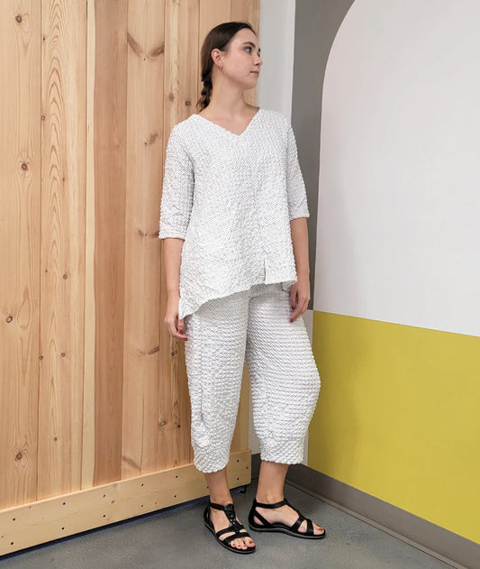 model wearing white with black dot v-neck flowy top with matching pants