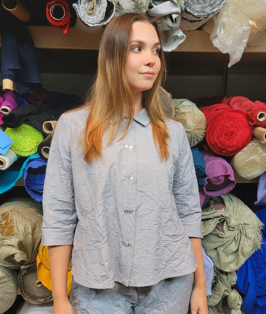 model in a grey and white pinstripe button down with 3/4 sleeves