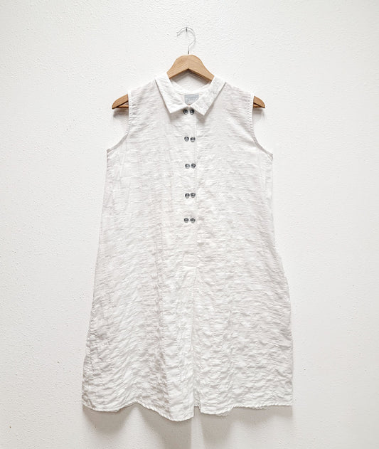 white sleeveless shirtdress with a textred body and black and white twin set buttons down the placket 