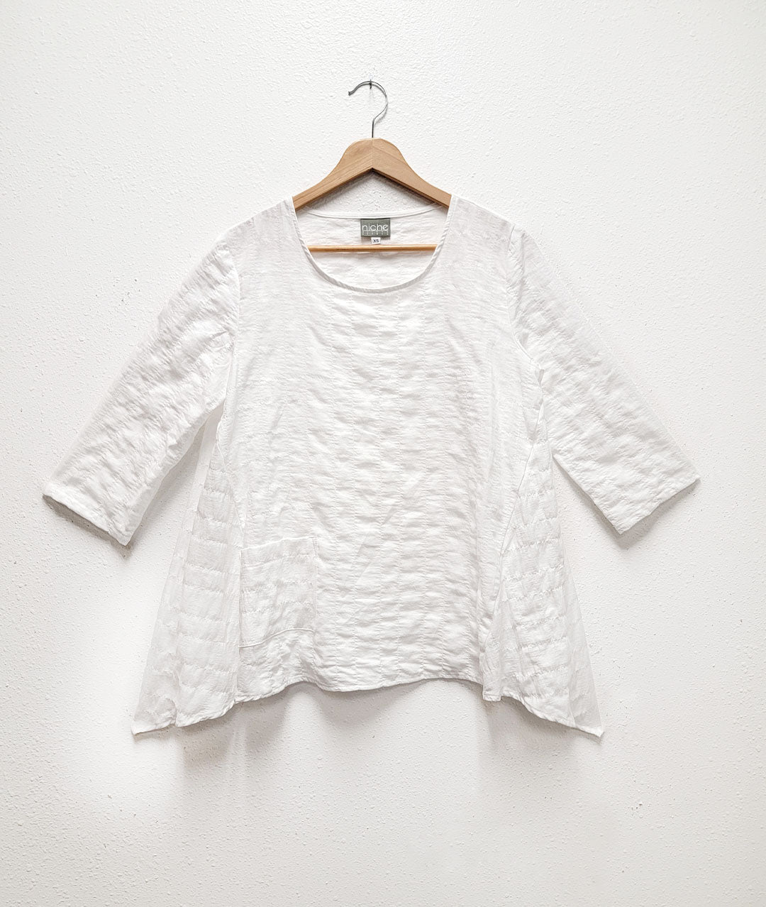 white textured pullover top with 3/4 sleeves and a large scale soft seersucker texture
