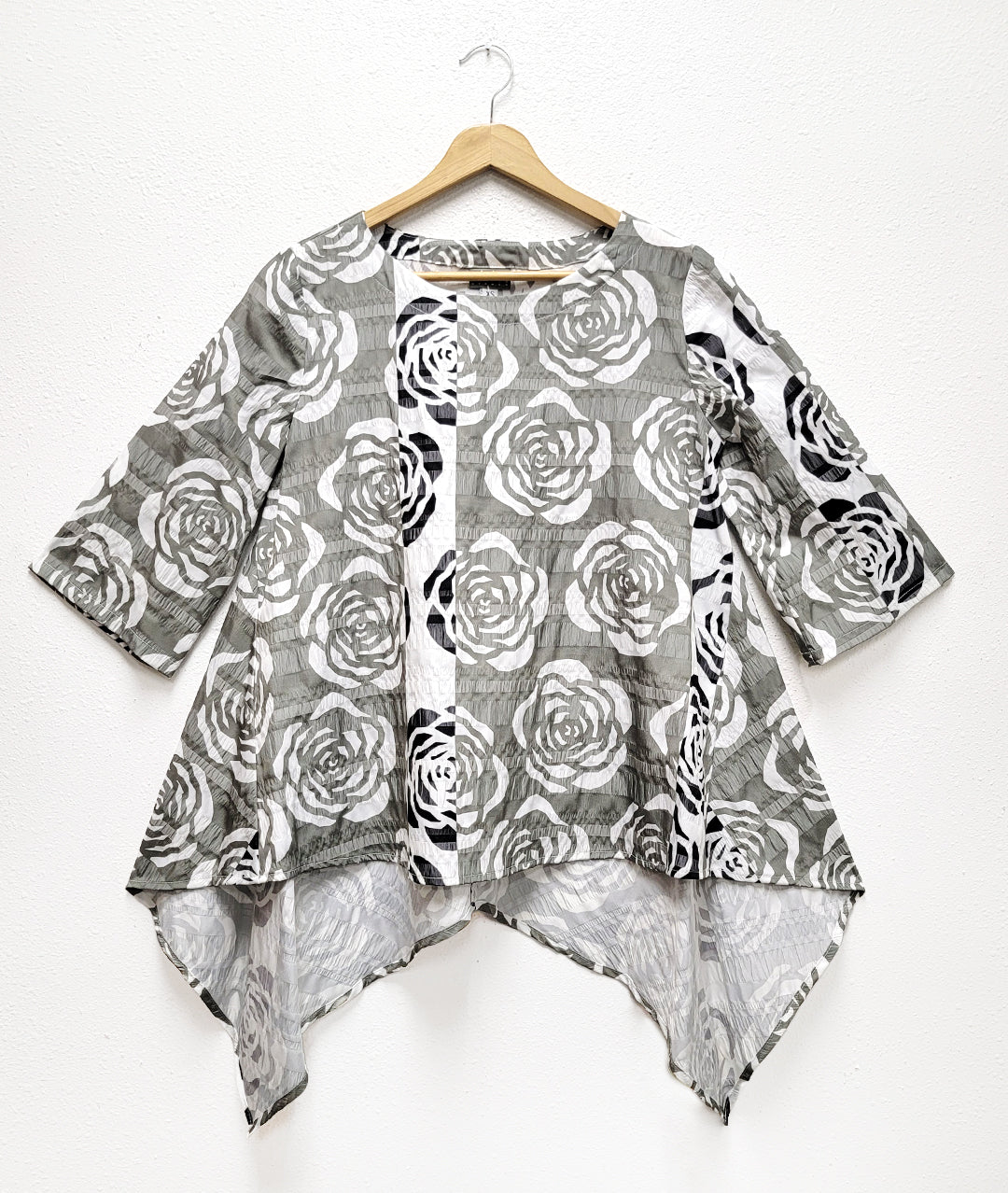 multi color rose print pull over top  with a wide body and a longer back hem with two draped points