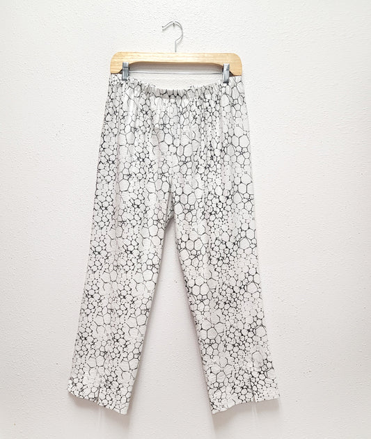 straight leg pant on a hanger. pant is white with a black bubble print all over